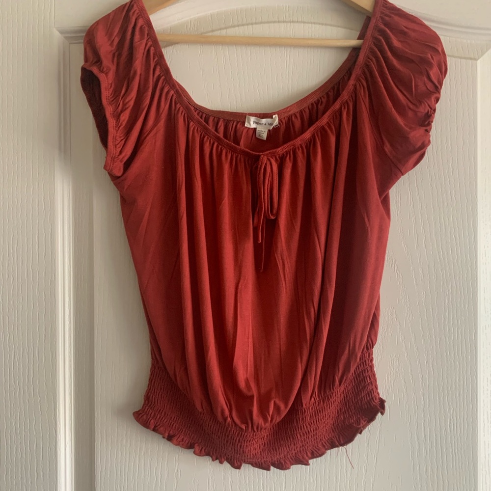 Cute little blouse.  Can be worn off the shoulder. Color is rust/burnt orange.